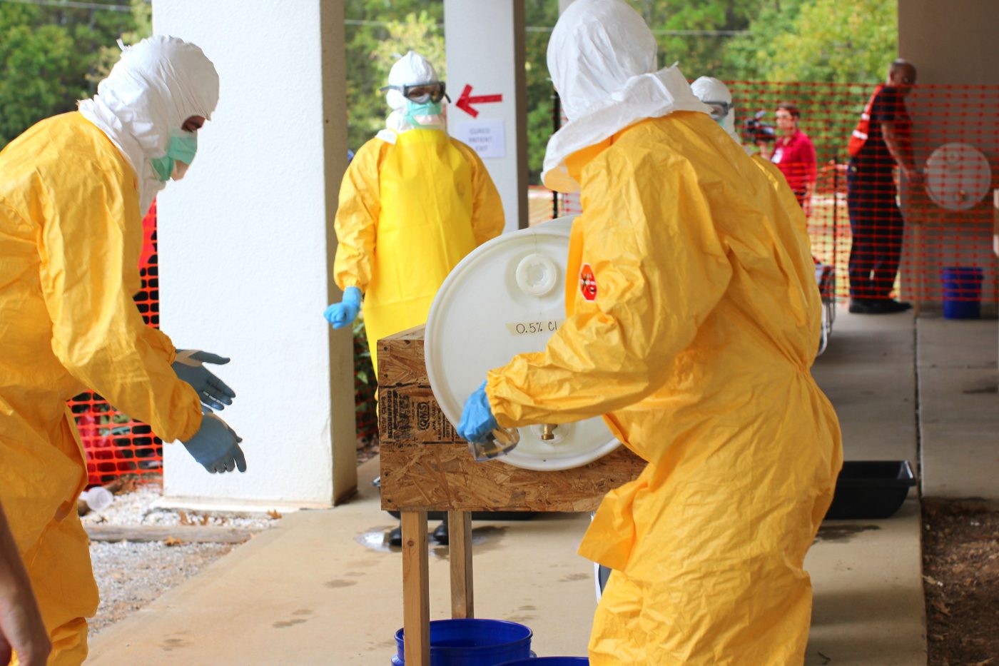 Health workers in full protective equipment at a decontamination station